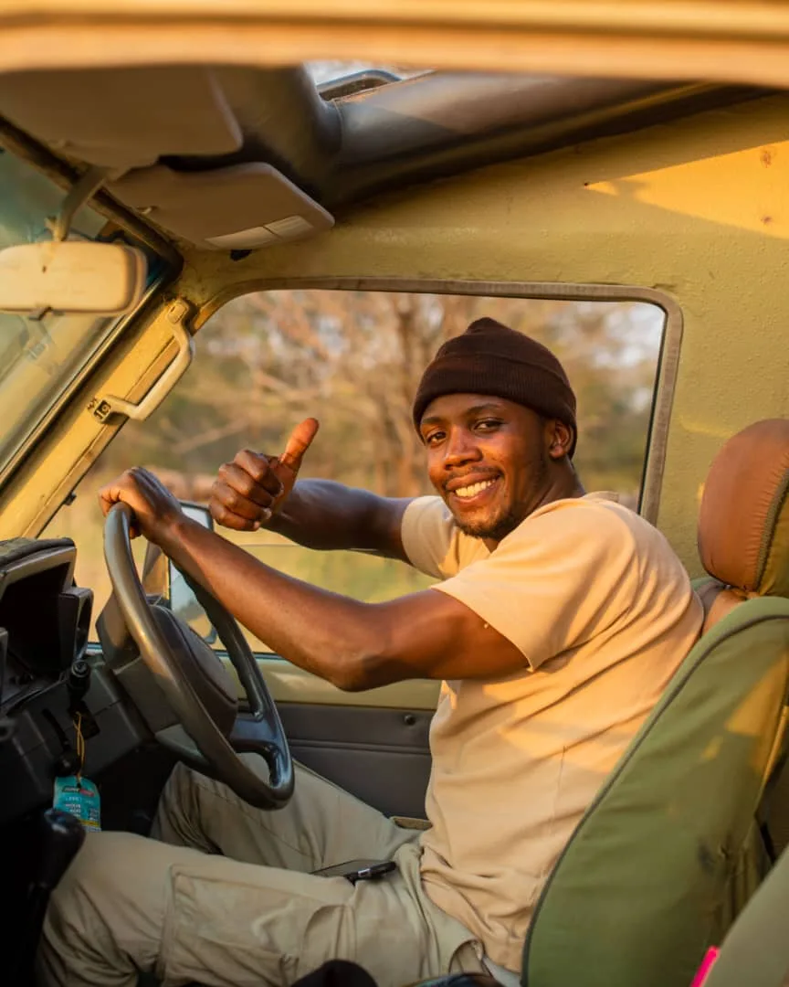Joshua Joseph smiling behind the wheel of his safari vehicle